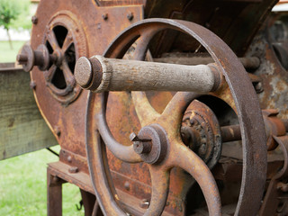 Vintage grain grinder machine. Old machinery details closeup. Rusty gear wheels.