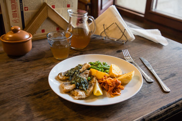 fish and chips plate with vegetables and lemon in a restaurant