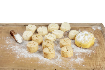 unbaked bread rolls on a wooden background isolated on white background