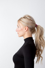 Eine blonde, junge, schöne Frau im Profil mit Pferdeschwanz © Hanker