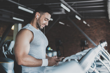 Happy beaded man hearing music in gym