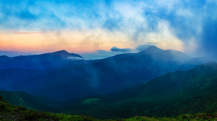 Fototapeta na wymiar Panorama of mountain ridges with clouds and fog in the morning evening time, at sunrise, sunset