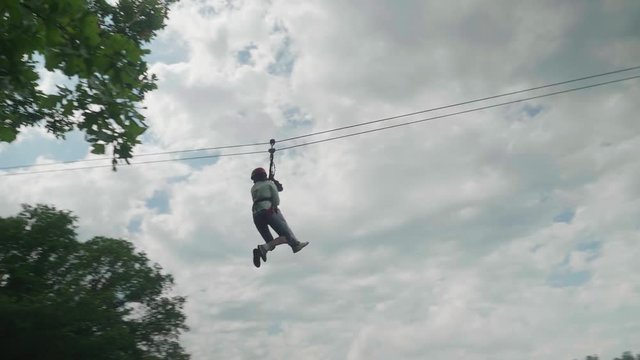 Two people riding on zip line and go straight into tree leaf