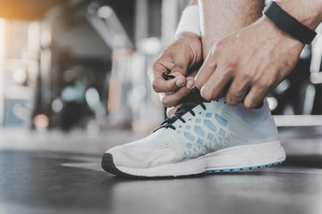 Athlete hands tying shoelaces in sports hall