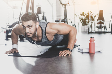 Serious unshaven athlete taking exercise