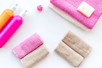 Preparing to take bath. Towels, shampoo, hair conditioner, soap on white background top view copyspace