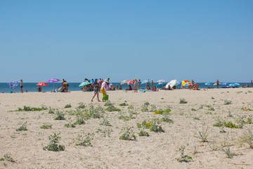People rest on a deserted beach on the edge of the Earth