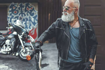 Serious old biker near garage