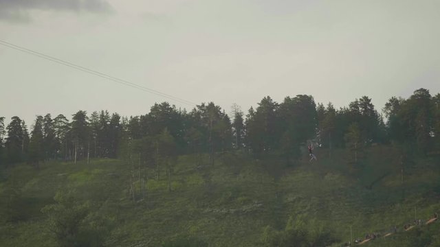 Guy ride zip line and makes video on smart phone