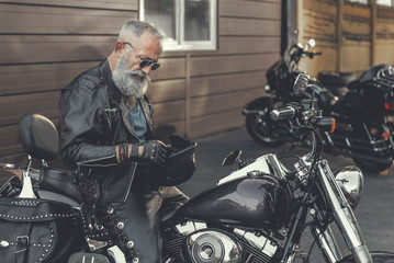Attentive old man keeping bike slam