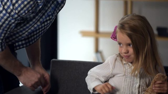 Caring father tickling his preschool cute daughter