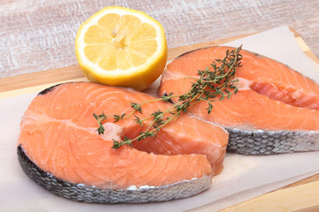 fresh raw salmon with spices and lemon on wooden cutting board. ready for cookin