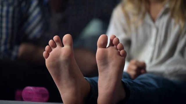 Close up of a little girls feet resting on the sofa