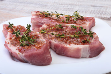 Raw pork chops, spices and rosemary on cutting board. Ready for cooking.