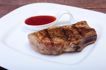 grilled pork chop with Cranberry sauce on plate on wooden board
