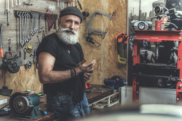 Interested bearded mature man in workshop
