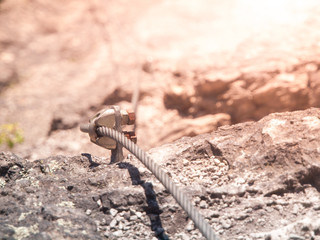 Close-up view of bolt via ferrata cable fastening. Outdoor rock climbing equipment.