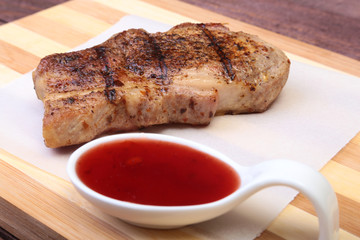 grilled pork chop with Cranberry sauce on plate on wooden board