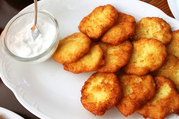 Tasty potato pancakes with sauce on white plate, closeup