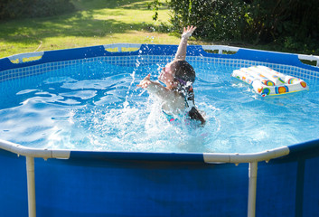 Child having fun in rubber swimming pool.