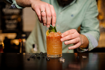 Bartender decorates a summerr cocktail no face