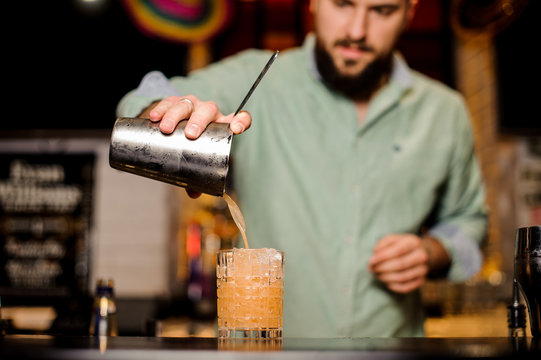 bartender making orange cocktail