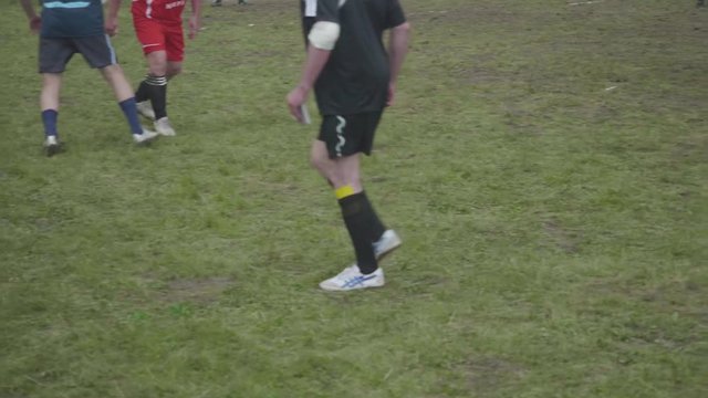 Legs of male soccer amateurs playing soccer in mountains. Part of festival