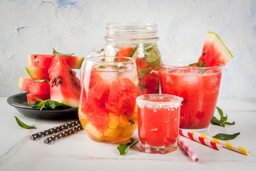 Set of watermelon summer drinks and cocktails: sangria, juice cooler cocktail, infused detox water, watermelon vodka shot. On a white marble table. Copy space