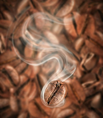 Coffee bean with hot steam close-up on a background of lots of coffee beans
