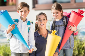 Mother and children on first day at school with candy cones