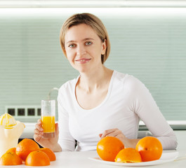 Adult woman cooking orange juice on juicer