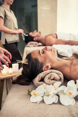 Obraz na płótnie Canvas Relaxed woman lying down on massage bed during facial treatment at Asian spa and wellness center