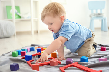 Cute little boy playing on floor at home