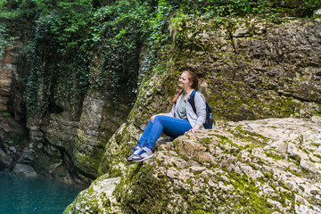 Naklejka na ściany i meble Sportstyle travel girl sitting and smiling in the mountains