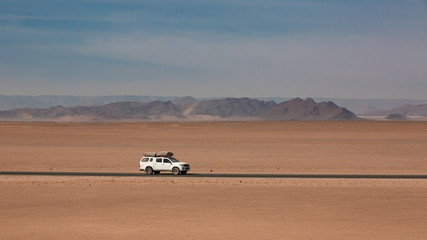 Car driving on a road in the Namib Desert