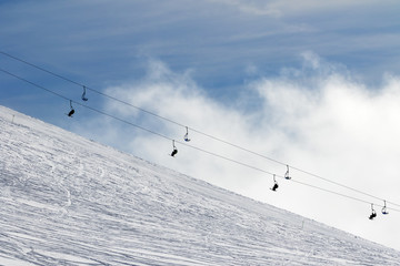 Fototapeta na wymiar Snow off-piste ski slope and chair-lift in fog