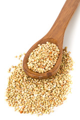 Raw, natural, uncooked buckwheat seed kernels in wooden spoon