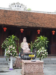 Quan Yin god marble statue in front of Chinese style shrine temple in Hanoi, Vietnam