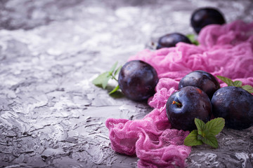 Fresh sweet plums on concrete background.
