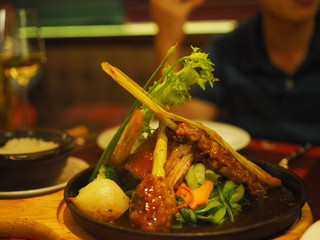 Grilled pork on hot heated metal pan dish in fine dining restaurant in Hanoi, Vietnam