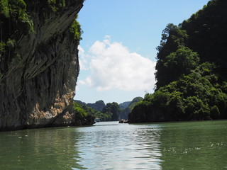 Green sea water with high cliff edges and light blue sky in Ha long bay, Vietnam