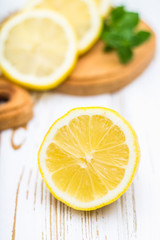 Lemons on a board on a white wooden background.