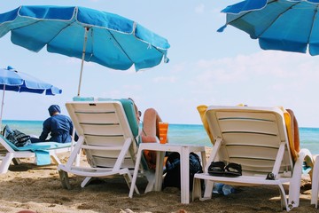 July, 2017 - People rest on deckchairs in the shade of beach umbrellas on Cleopatra Beach (Alanya, Turkey).