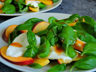Fitness salad with peach on a plate. Salad peach basil mozzarella.