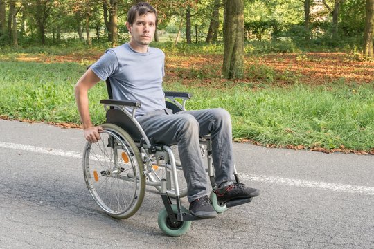 Young handicapped or disabled man on wheelchair.