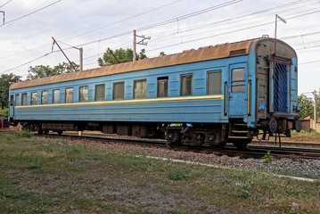 Синий пассажирский вагон на рельсах на железной дороги