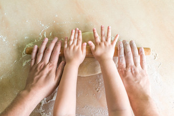 Children and dad hands rolled dough