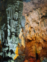 Grey grungy Stalactite pillar with yellow light up decoration in the cave