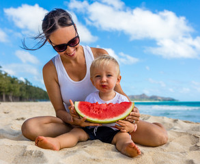 Mother and Son Enjoy Eating Delicious Ripe Watermelon on Beautiful Beach During Summertime