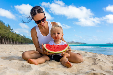 Mother and Son Enjoy Eating Delicious Ripe Watermelon on Beautiful Beach During Summertime